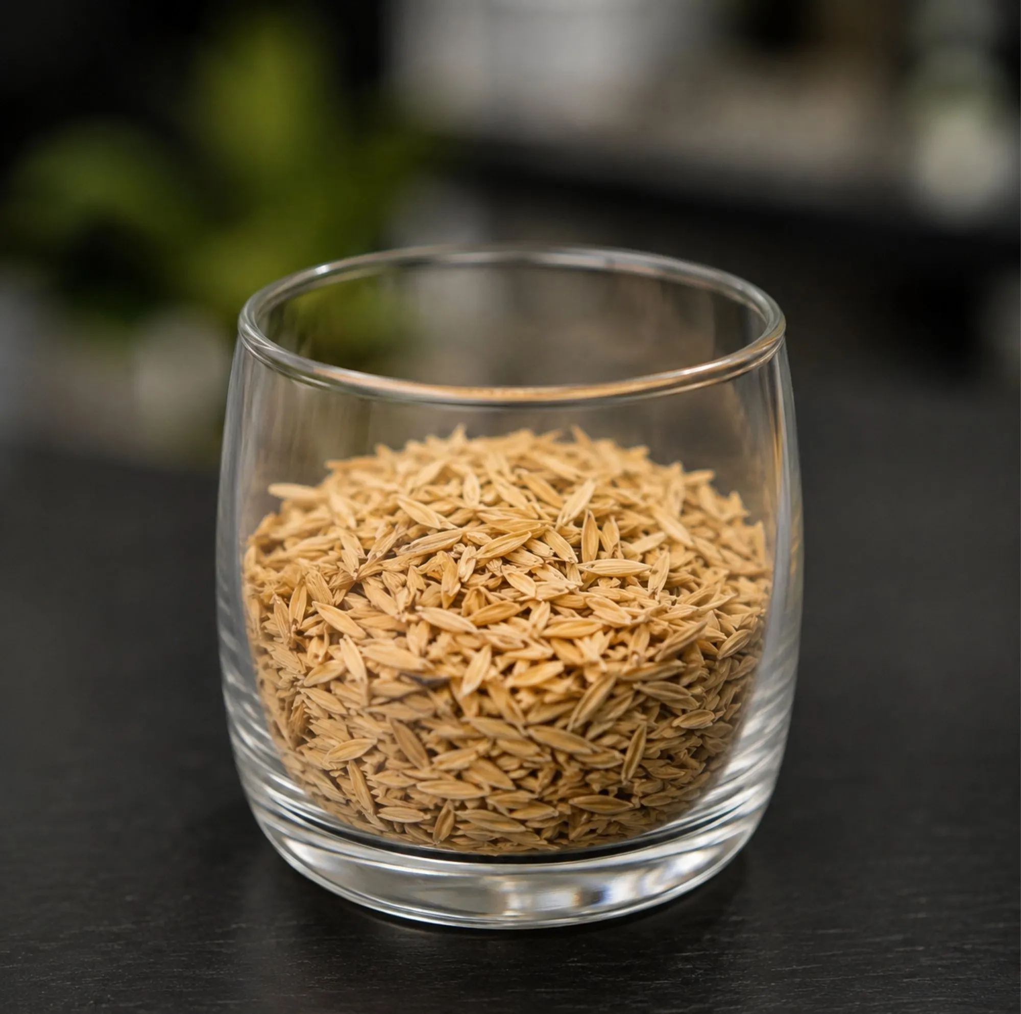 A sample of paddy, unhusked Rice, in a clear glass